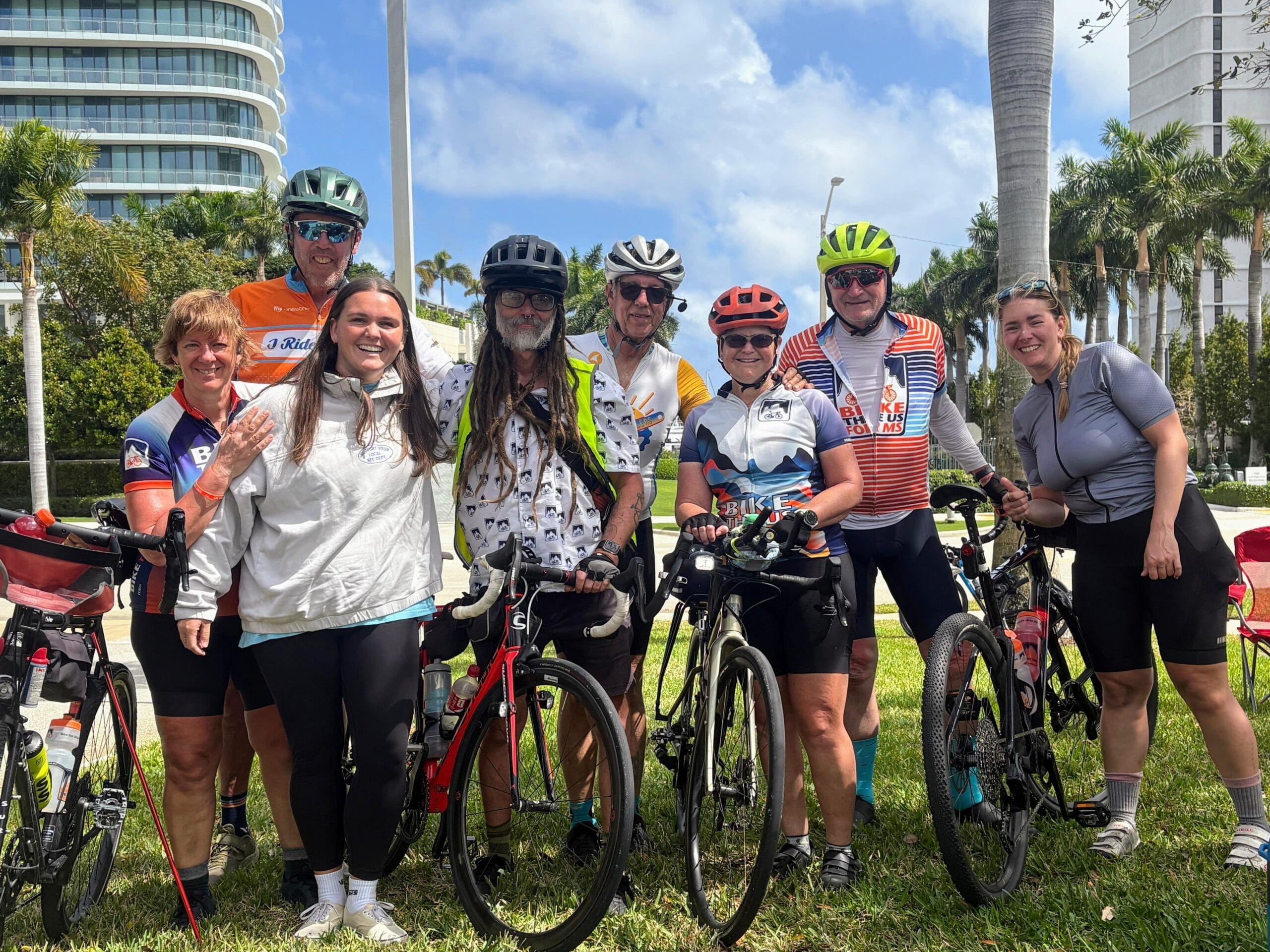 Bike the US for MS cycling team posing together in Florida, with blue skies and palm trees in the background.